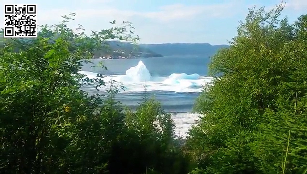 Iceberg rolling over and breaking