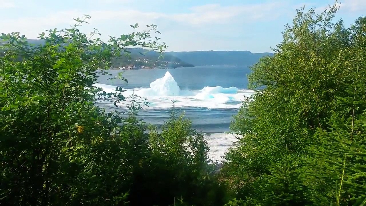Iceberg rolling over and breaking.