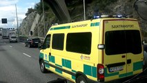 Ambulans med blåljus o sirener nära att bli påkörd av en långtradare på E4 Essingeleden