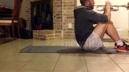 Man works out while playing the trumpet