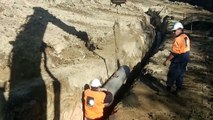 In-cab view of 35ton excavator laying 300mm concrete pipes.