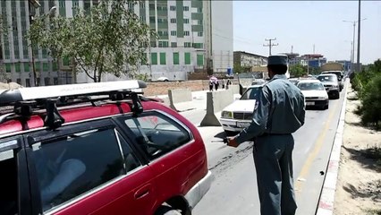Afghan policemen search passengers at Kabul checkpoint