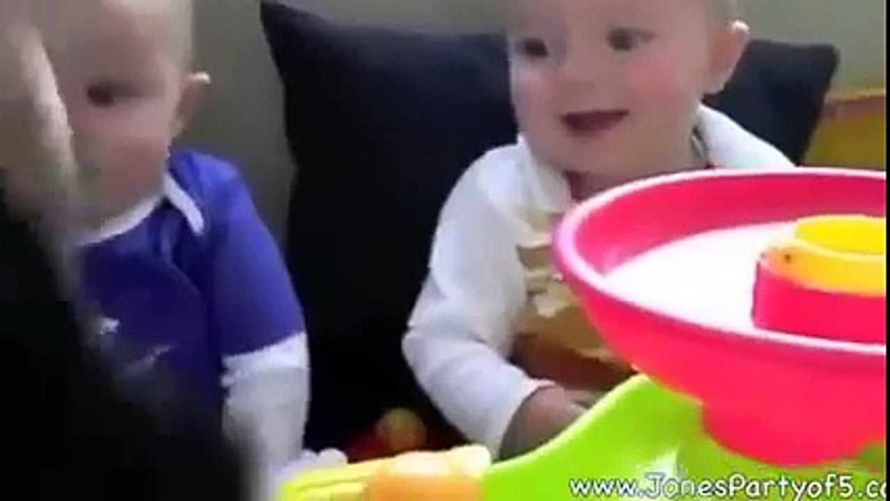 Baby twins having fun with a stuffed animal