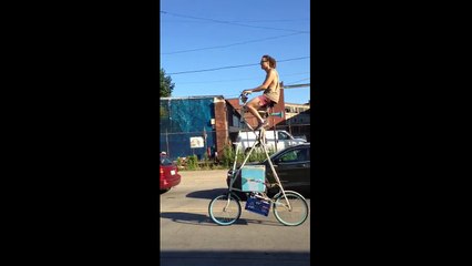 Man cycles down Detroit street on tall bike