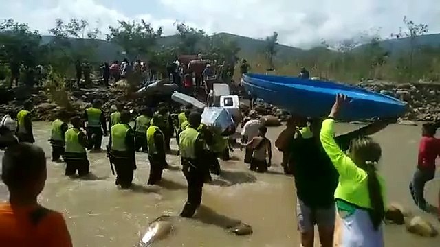Colombianos cantan el himno de su país mientras cruzan al río Táchira tras ser deportados