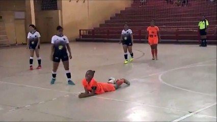 Une joueuse de Football Indoor met un grand coup de pied dans la tête de son adversaire au sol -