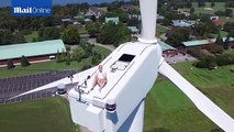 A drone catches a man sunbathing on top of a wind turbine. How did he even get there?