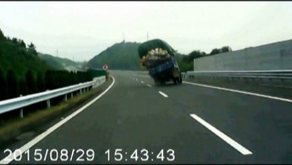 Overloaded truck turns over on highway