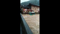 Floods carry bus into river where it sinks