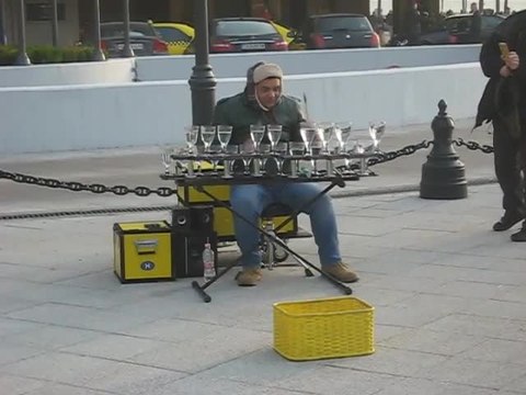 Street performer amazingly plays music on water glasses