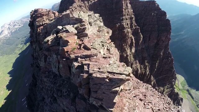 Deux randonneurs sautent au dessus du vide entre deux montagnes (Colorado)