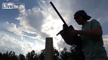 Shooting sniper rifle from the standing position off a rickety wooden obstacle.