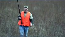 Un chasseur attrape un oiseau à mains nues