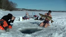 Naked man fishing by diving  under ice