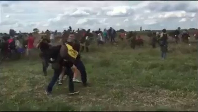 A Hungarian camerawoman trips refugees who are running from police