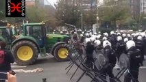 Belgique, pendant une manifestation, deux tracteurs forcent un imposant barrage de police.