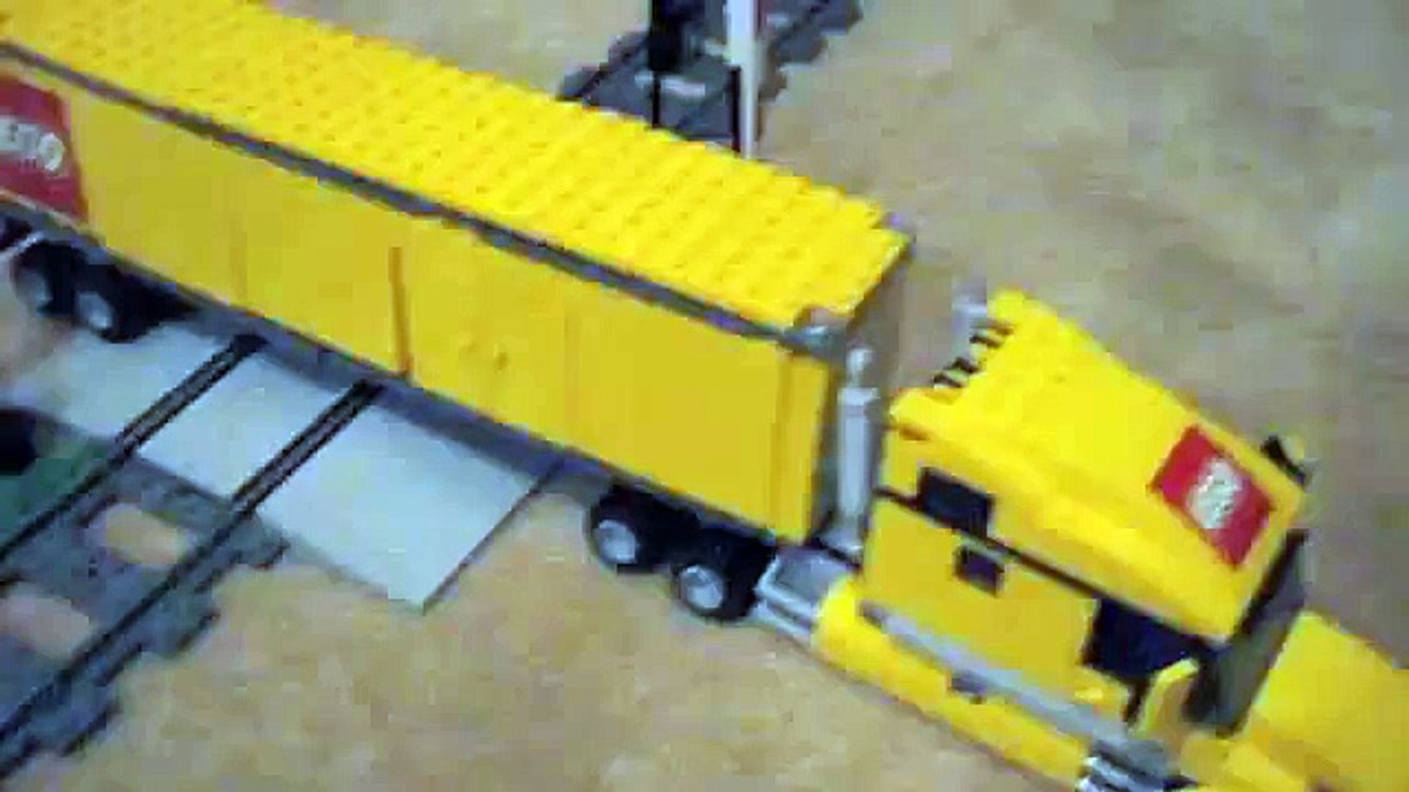 lego train plows though a semi truck
