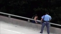 Police officer hugging distressed man after talking him off bridge