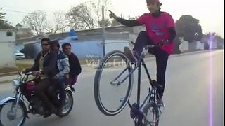 A beautiful boy doing one wheeling on by cycle