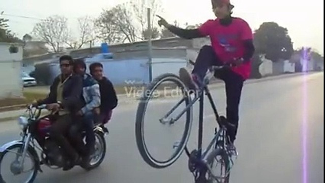 A beautiful boy doing one wheeling on by cycle