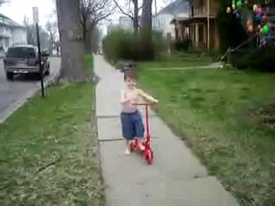 Reese snapping fingers and riding scooter