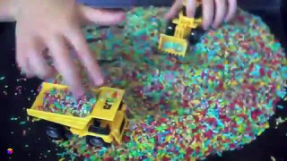 Trucks for children kids. Toy construction trucks. Sensory activity for toddlers - rainbow rice
