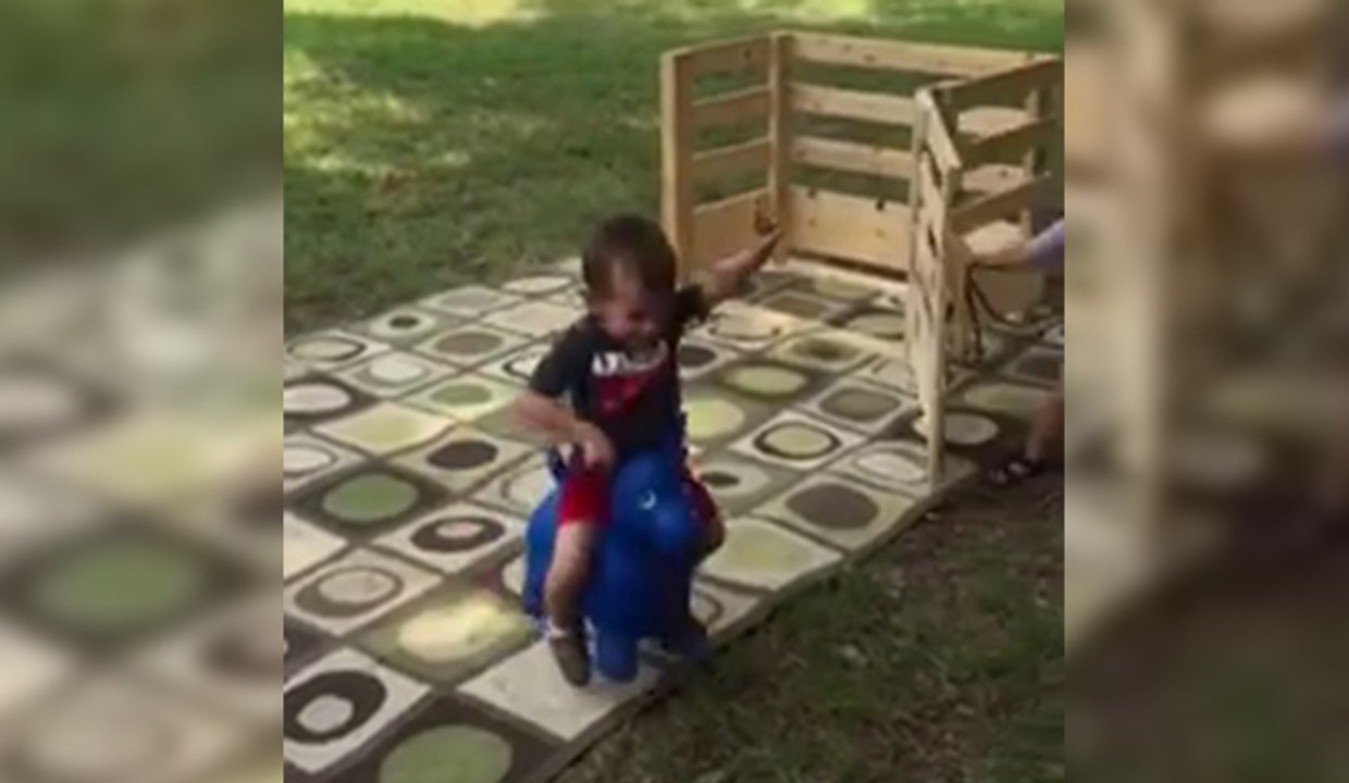 Un enfant fait du rodéo sur un cheval en plastique