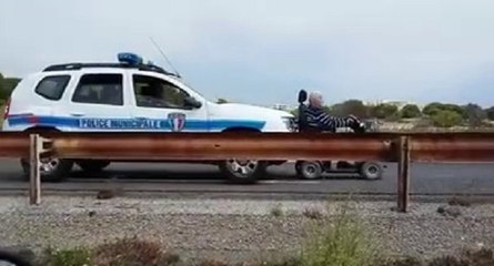 Voiture de la police municipale pousse un fauteuil roulant