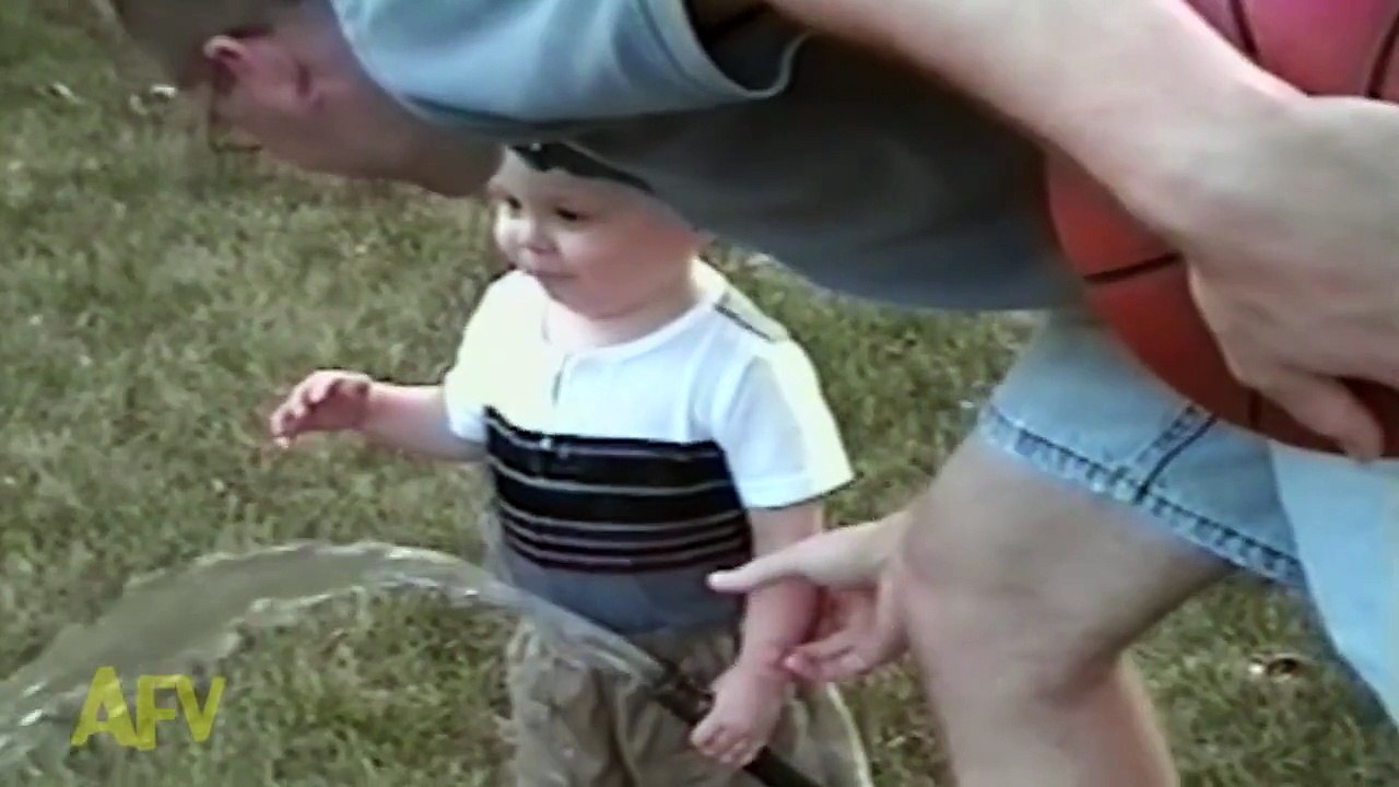 Adorable baby boy attempts to drink water from a hose (1)