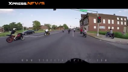 Un motard en Harley-Davidson fonce dans un feu tricolore