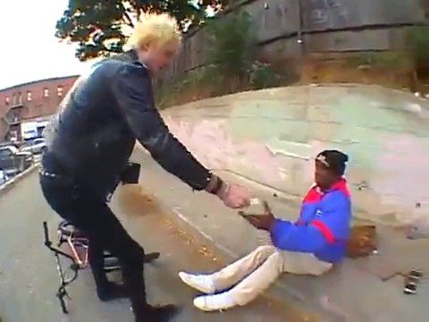 BMX rider jumps and lands on bum's head lying down the streets