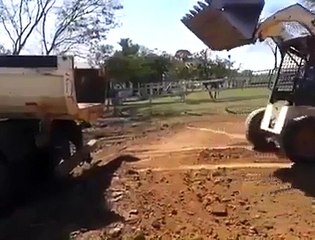 Il Gare son Tractopelle avec une Parfaite Maîtrise