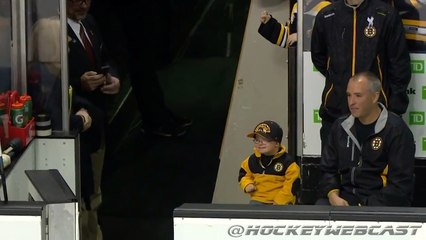 Un enfant fait des checks avec les joueurs de son équipe favorite de hockey sur glace
