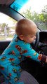 Adorable Baby put the music louder and dance while standing in front of the steering Wheel