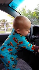 Adorable Baby put the music louder and dance while standing in front of the steering Wheel