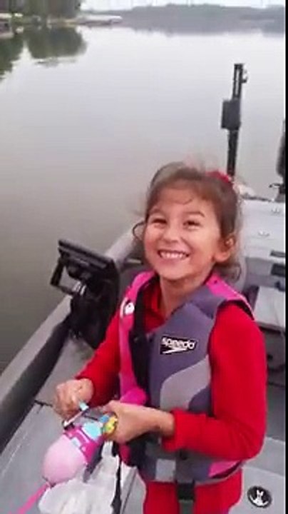 Une petite fille attrape un poisson avec sa canne à pêche Barbie