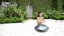 Pretty Asian Lady Plays Saucer Shaped Instrument
