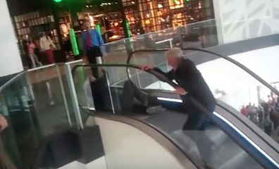 Deux vieux font la course dans un escalator pour un hamburger gratuit