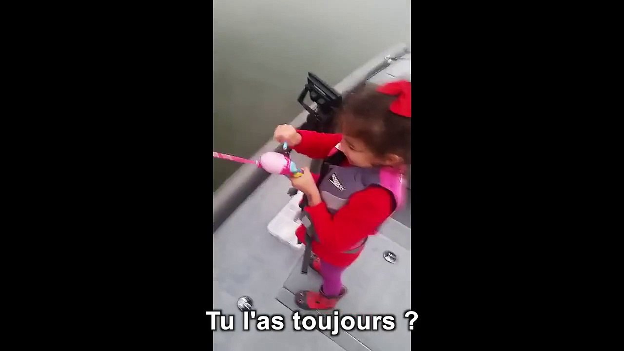 Une petite fille attrape un poisson avec sa canne à pêche barbie