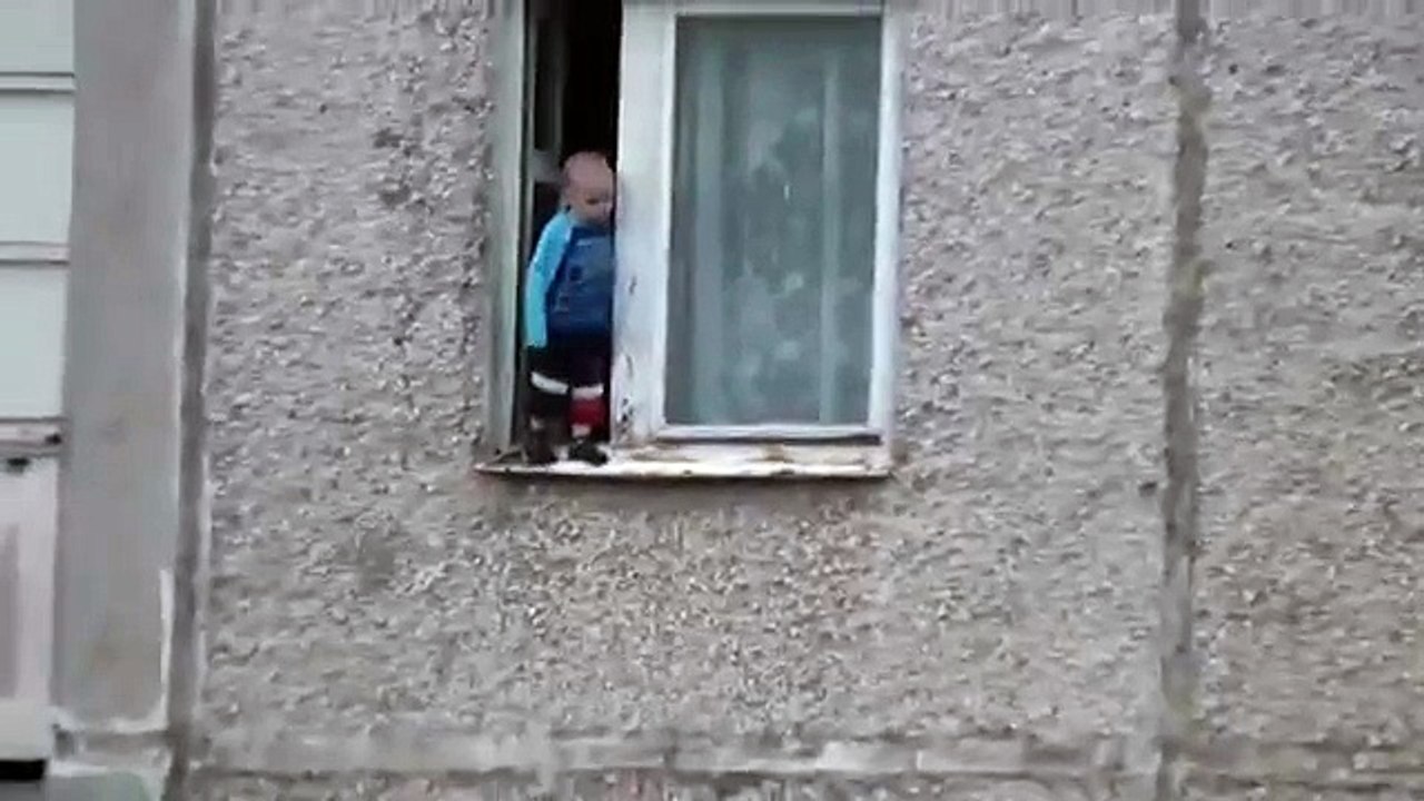 Un enfant sur le bord d'une fenêtre au 8ème étage