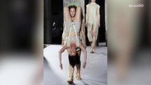 Models walk the runway carrying other models in bizarre Rick Owens show