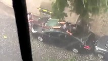 Un homme essaye désespérément de protéger sa voiture de la grêle