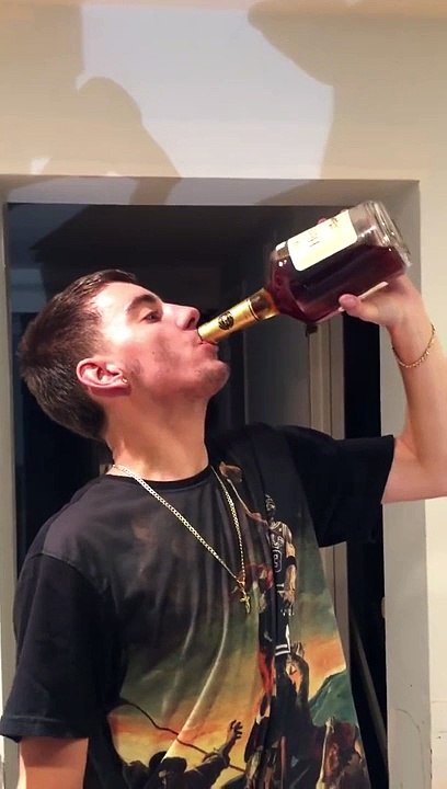 Un jeune boit une bouteille de Cognac cul ses