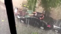 Un homme fait l'essuie glace humain pour protéger sa voiture de la grêle