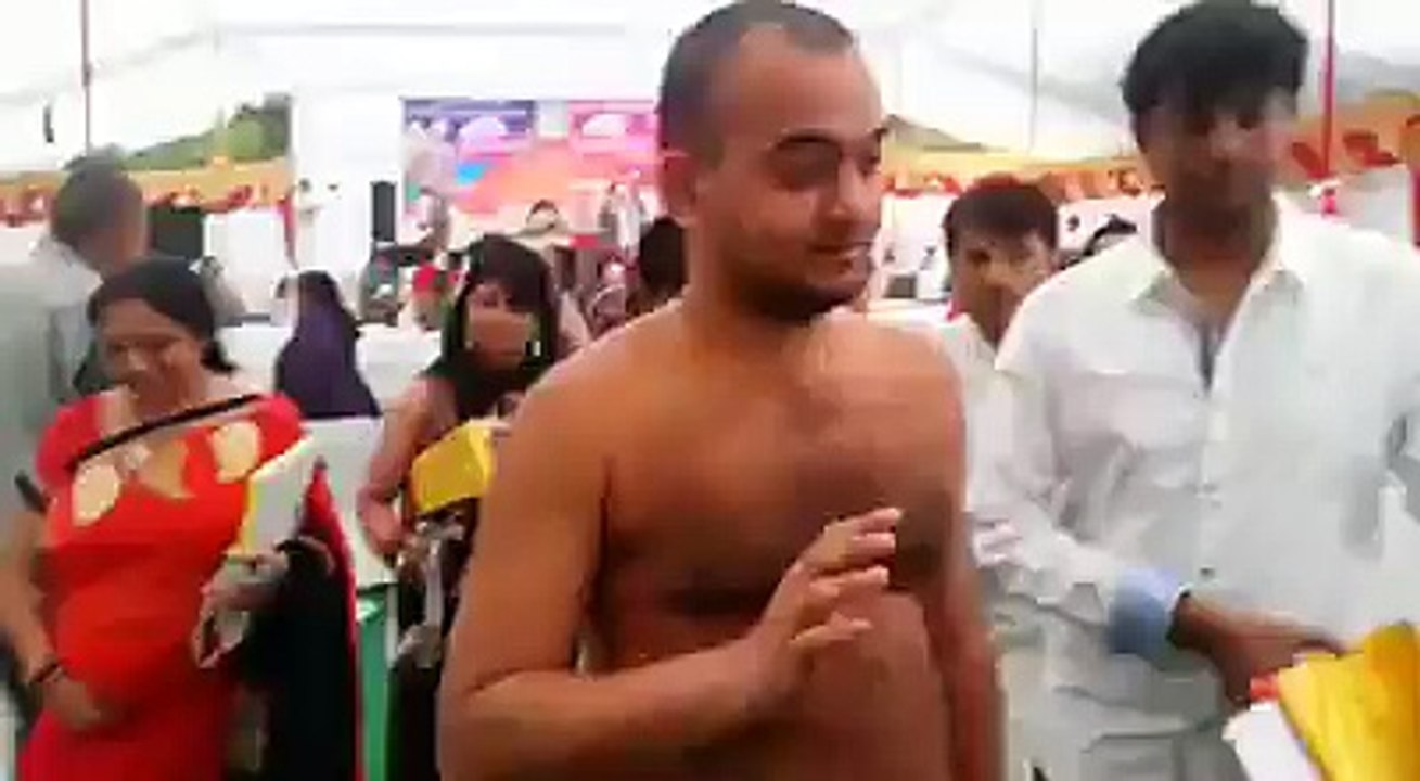 Indian people worships a naked man in public.