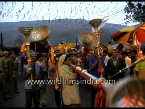 Men play large traditional metal horns during celebration of Dussehra in Kullu