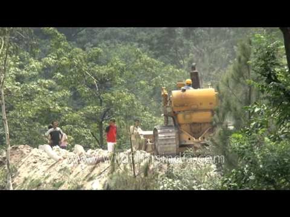Bull-dozer repairs road, truck falls into gorge and creates Himalayan traffic jam