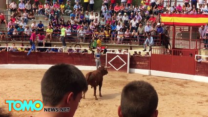 Dude jumps over barrier while running from bull, bull follows