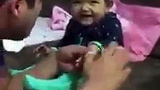 طفلة تضحك مع أبيها وهو يقص ضوافرها