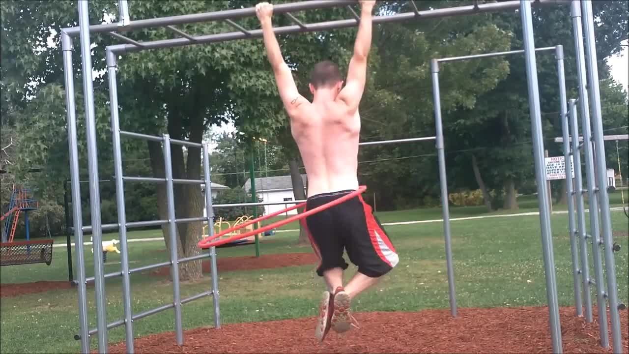 Talented athlete does pull-ups while hula hooping